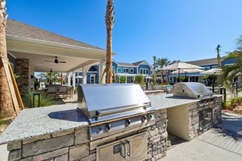 Outdoor kitchen with built in grills and stone countertop
